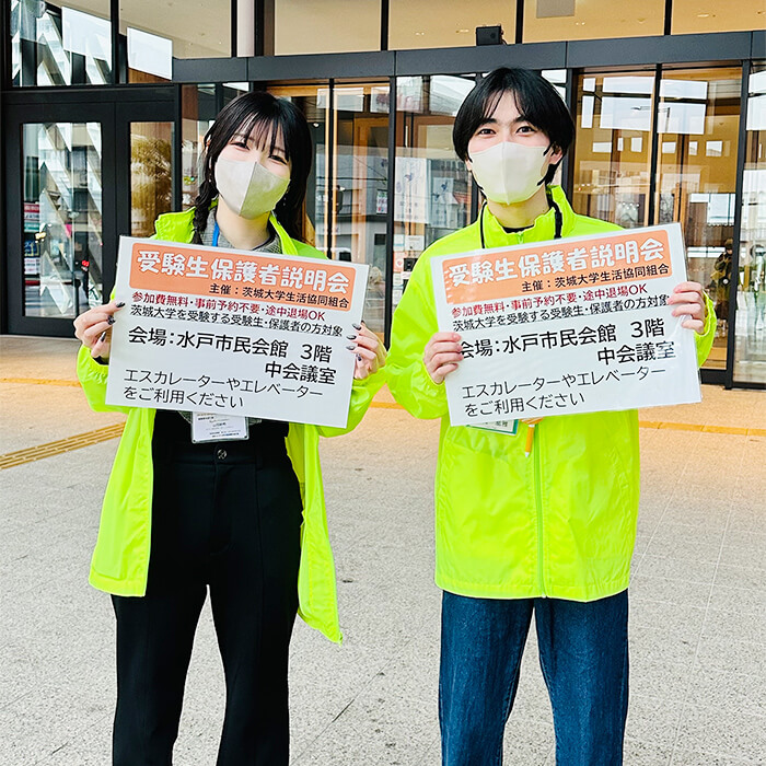 水戸市民会館前にて「入学準備説明会」の会場案内をだす先輩茨大生たち